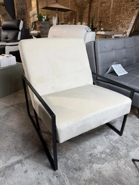 Jasnobeżowy fotel DELARY tapicerowany welurem, z czarną metalową ramą, dostępny w Home & Garden Outlet pod Wrocławiem.