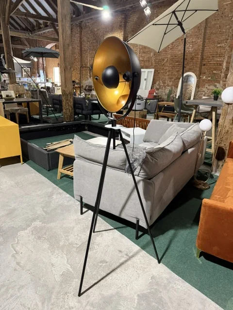 Złota lampa podłogowa THAMES z metalowym kloszem i czarną podstawą na trzech nogach, dostępna w Home & Garden Outlet pod Wrocławiem.