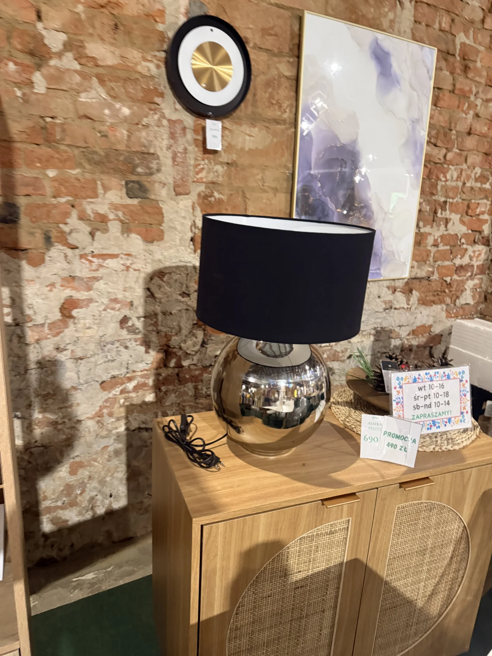 Elegancka lampa stołowa SOBRAMATI ze srebrną połyskującą podstawą i czarnym kloszem. Stylowy dodatek do salonu, sypialni lub gabinetu.