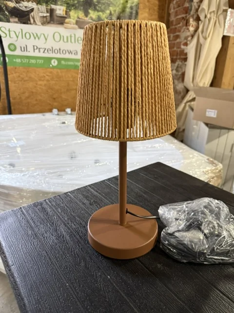 Brązowa lampa stołowa HANGER z metalową podstawą i dekoracyjnym plecionym abażurem, dostępna w Home & Garden Outlet pod Wrocławiem.