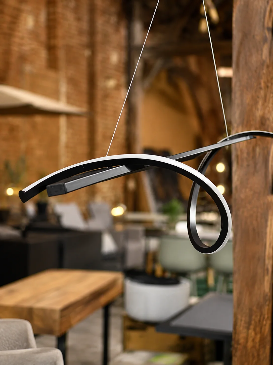 Czarna lampa wisząca LED BODRI z falowaną metalową formą i zintegrowanym oświetleniem, dostępna w Home & Garden Outlet pod Wrocławiem.
