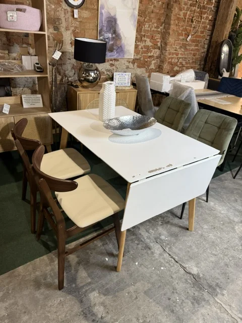 Biały stół do jadalni rozkładany MEDIO 120/155 × 80 cm z drewnianymi nogami, egzemplarz outletowy z widocznymi uszkodzeniami blatu, dostępny w Home & Garden Outlet pod Wrocławiem.