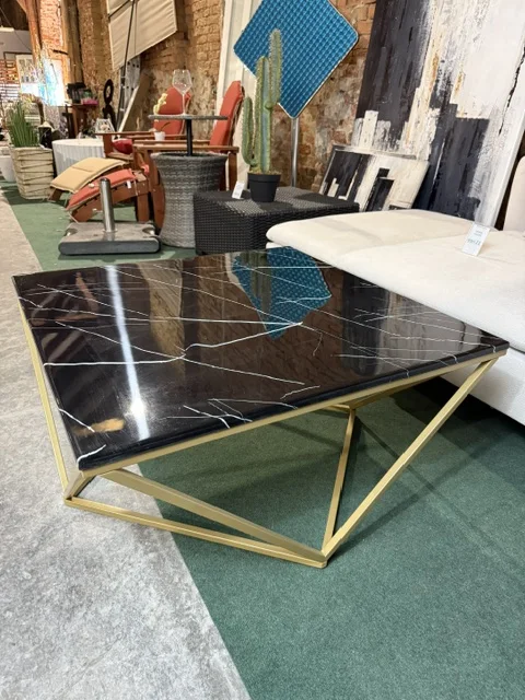 Stolik kawowy MALIBU z czarnym blatem z efektem marmuru i złotym geometrycznym stelażem, dostępny w Home & Garden Outlet pod Wrocławiem.