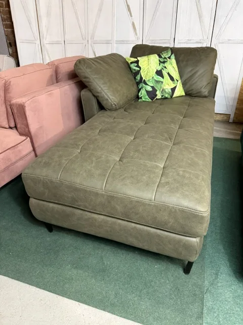 Zielony szezlong prawostronny REBAIS z ekoskóry, z pikowanym siedziskiem, czarnymi metalowymi nogami i dwiema poduszkami, dostępny w Home & Garden Outlet pod Wrocławiem.