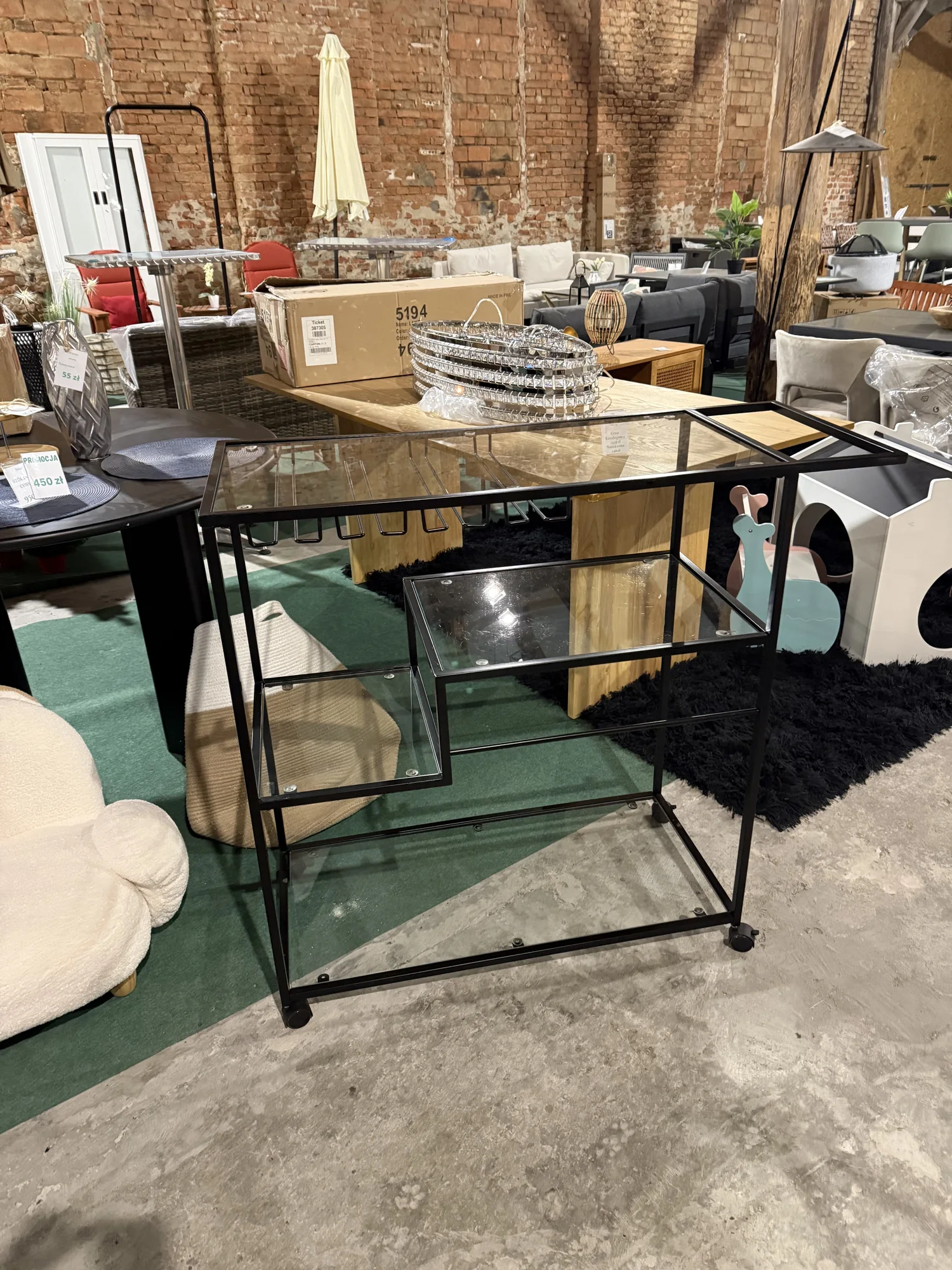 Czarny metalowy wózek kuchenny MARCOLA ze szklanymi półkami i kółkami, dostępny w Home & Garden Outlet pod Wrocławiem.
