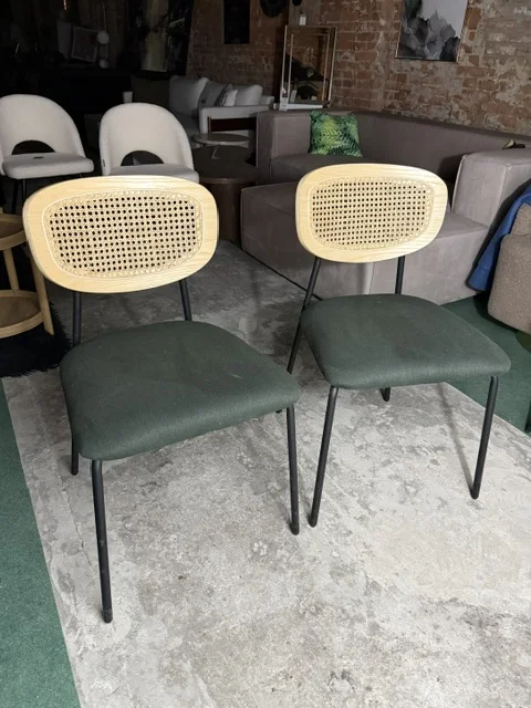 Zestaw 2 krzeseł do jadalni MAYETTA z rattanowym oparciem, ciemnozielonym siedziskiem i czarnymi nogami, dostępny w Home & Garden Outlet pod Wrocławiem.